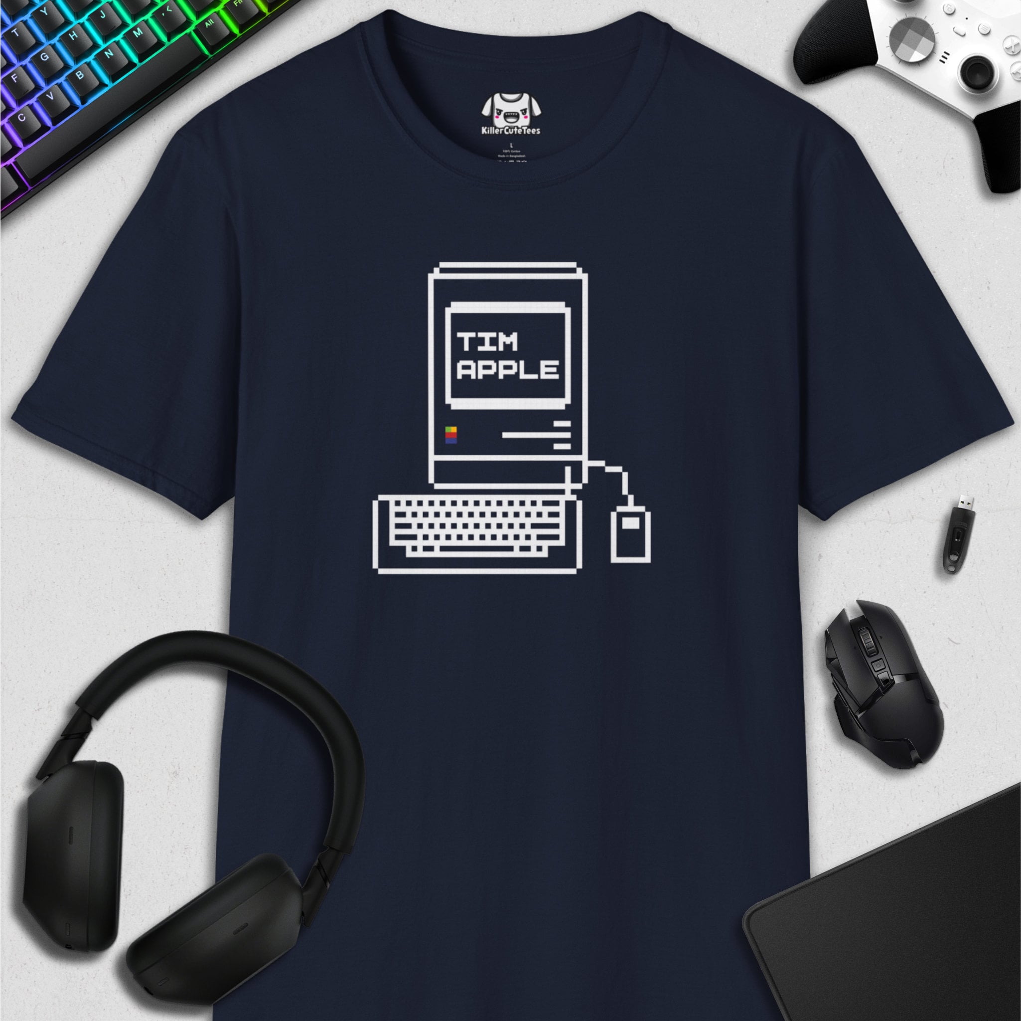 Navy blue t-shirt with computer graphic design on a desk with tech accessories.