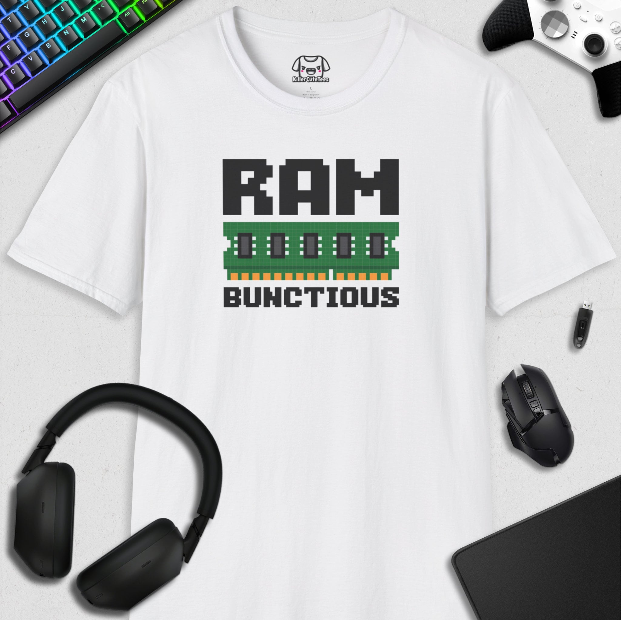 White t-shirt with 'RAM BUNCTIOUS' graphic design, surrounded by gaming accessories on a light gray background.